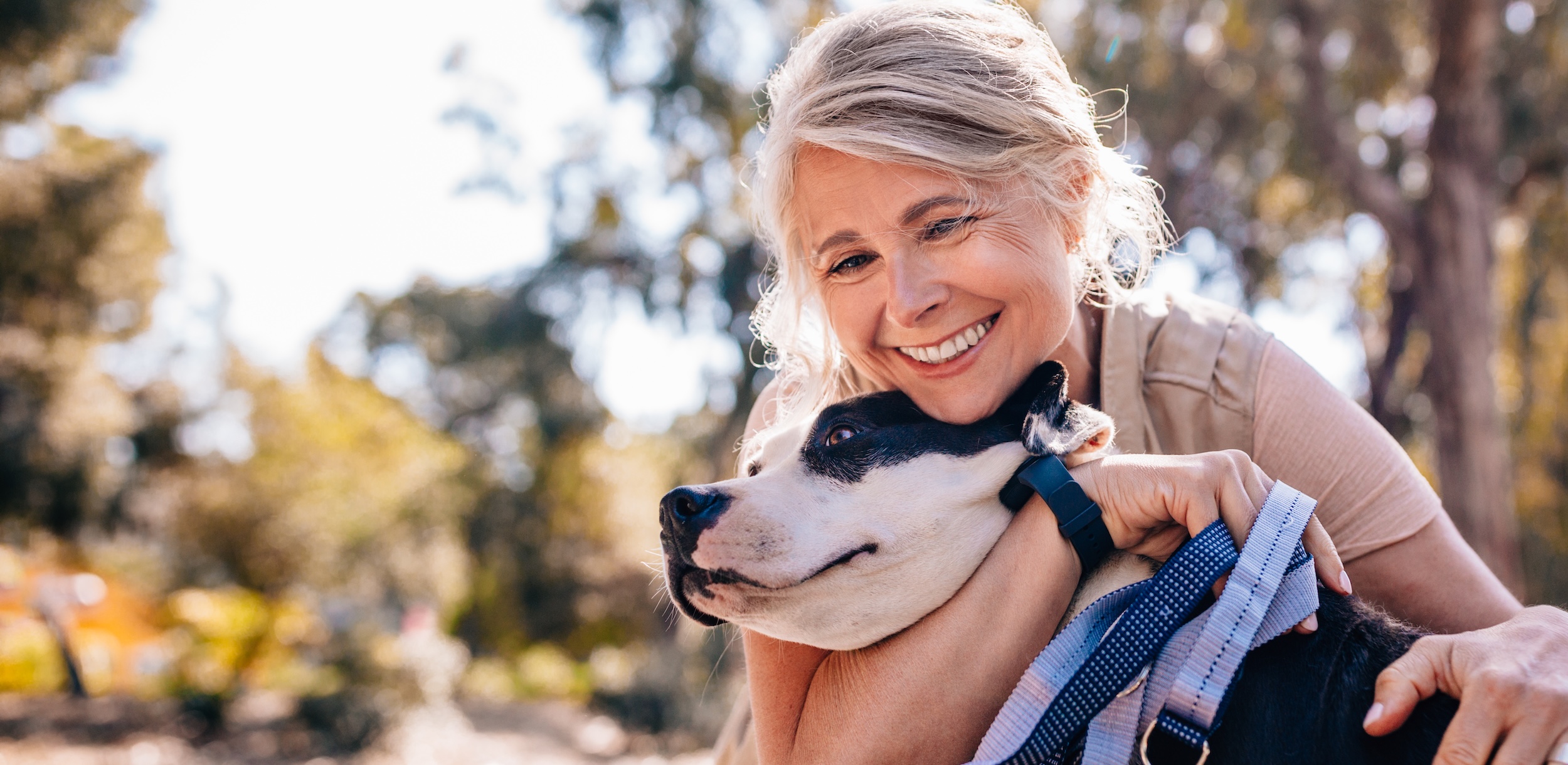 An older woman hugging a dog